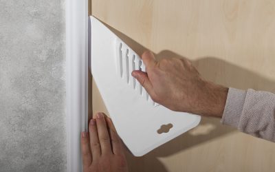 hands-putting-up-decorative-vinyl-with-tool